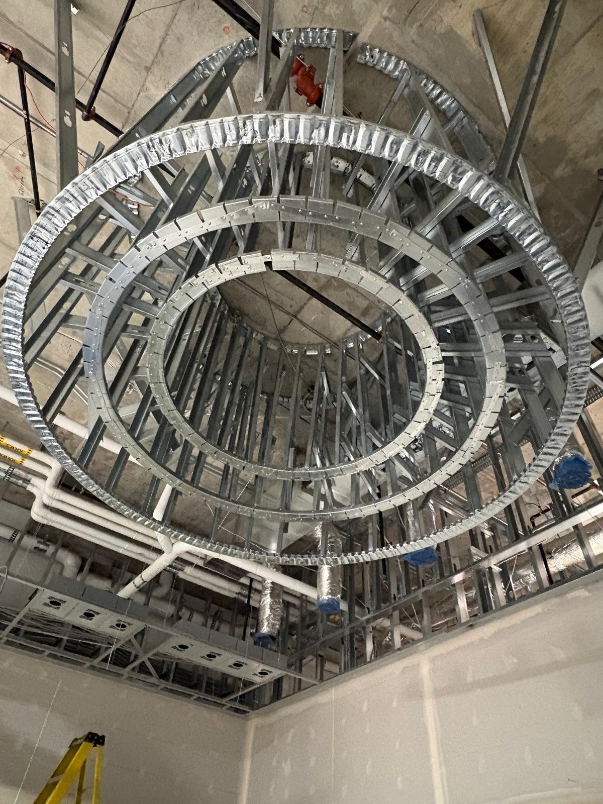 Custom circular steel ceiling framing by Embark Interior Ltd